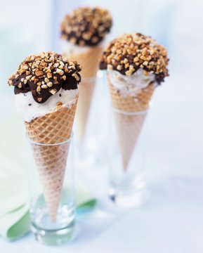 Three cones of stracciatella ice cream with chocolate & nuts