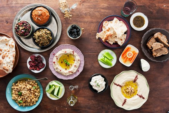 An assortment of Middle Eastern dips with bread, olives and vegetables