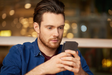 people, technology and leisure concept - close up of man with smartphone at restaurant