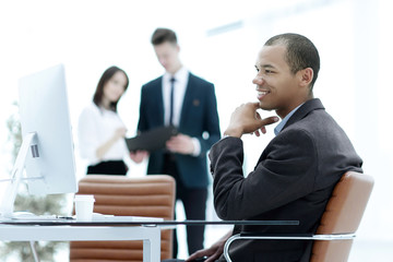 confident young businessman on blurred background office