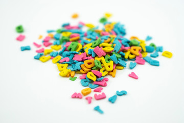 Sprinkle alphabet cake decoration on white background.