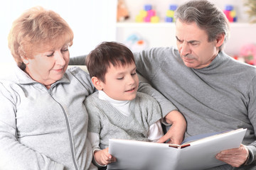 grandmother and grandfather reading book to his grandchild.the concept of education