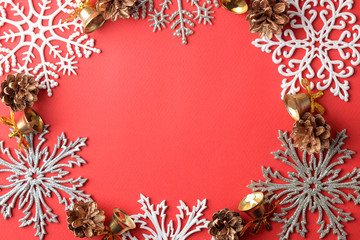 frame made of snowflakes and christmas decor on a red background. view from above