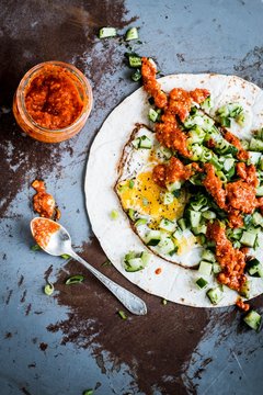 Tortilla with fried egg, vegetables and chilli sauce