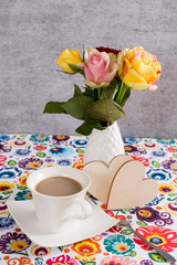 Coffee cup and rose in the vase and wooden hearts