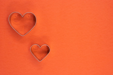 Cookie cutter love shape on red background.