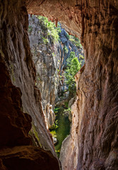 Views through the tinted cave to the narrow canyon