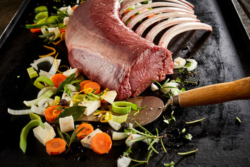 Rack of ribs grilling on hot plate with vegetables