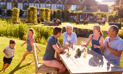 Multi Generation Family Enjoying Outdoor Summer Drink At Pub