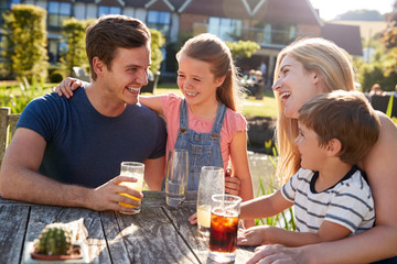 Family Enjoying Outdoor Summer Drink At Pub