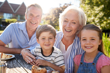 Portrait Of Grandparents With Grandchildren Enjoying Outdoor Summer Snack At Cafe - obrazy, fototapety, plakaty