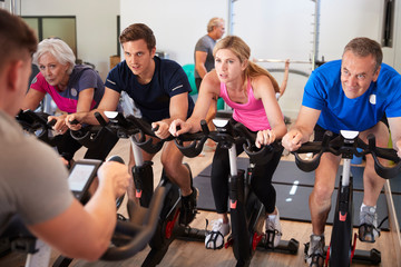 Male Trainer Taking Spin Class In Gym