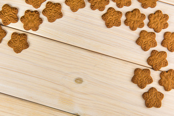 Christmas or New Year gingerbread cookies with snowflakes framed on wooden background with space for text and your design. Top view with copy space. Christmas card.