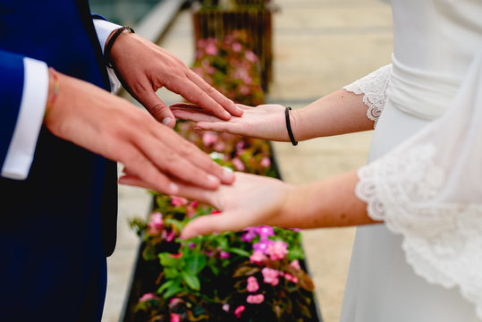 Newly-married couple stroking the palms of their hands.
