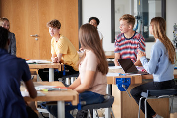 Group Of High School Students Sitting At Work Benches Having Discussion In Design And Technology...