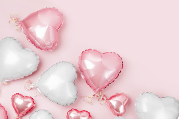 Air Balloons of heart shaped foil  on pastel pink background. Love concept. Holiday celebration. Valentine's Day or wedding/bachelorette party decoration. Metallic balloon