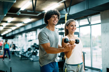 Personal trainer helping young woman reach goals