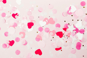 Background of pale pink paper confetti shape of heart, holiday concept