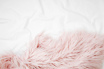 Bedding with a pink fluffy fur plaid. Copy space. Flat lay, top view