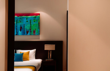 Modern contemporary style bedroom with white curtain, colourful pillows, bed side lamp