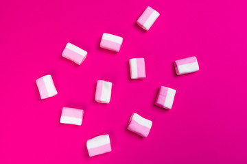 Fototapeta na wymiar marshmallows on a pink background. top view