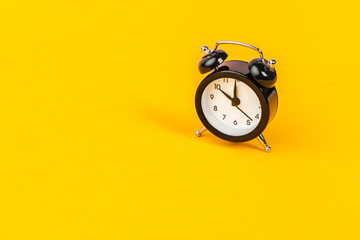 Alarm clock on bright yellow background  close up