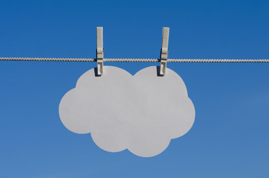 Clothespin, paper cloud and sky