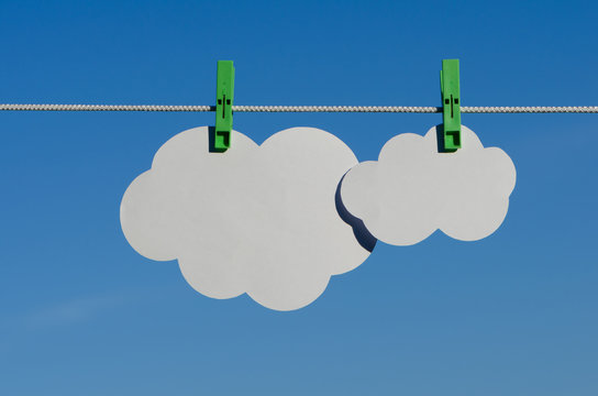 Clothespin, paper clouds and sky