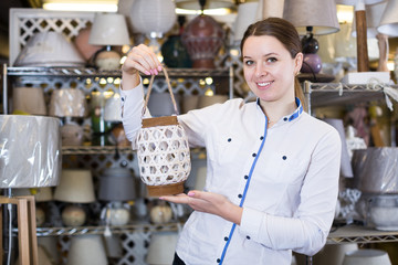 Beautiful woman is standing with modern lamps