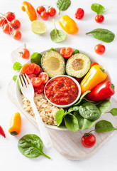 vegan buddha bowl. healthy lunch bowl with avocado, tomato, bell peppers, quinoa and salsa