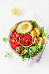 vegan buddha bowl. healthy lunch bowl with avocado, tomato, sweet corn and salsa