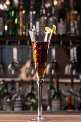 A strong alcoholic cocktail in a glass of old fashion is on the bar in the restaurant.
