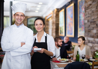 Smiling waitress with chef in the restaurant