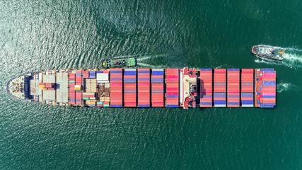 Aerial top view Tug boats drag container ship to sea port for unload container to container...