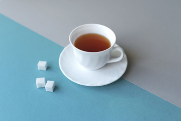 White cup of tea with sugar.