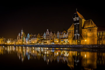 Famous medieval crane in the Gdansk , Poland in the night with scenic reflection on water - canal of old Motlawa