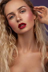 beauty portrait of a female with long wavy blonde hair with makeup