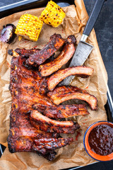 Barbecue spare ribs St Louis cut with hot honey chili marinade and corn as top view in a skillet