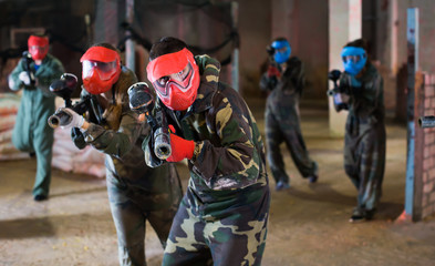 Paintball team in red masks are ready for attack