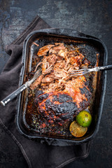 Traditional barbecue pulled pork piece of Bosten butt torn to bits as close-up in an old skillet