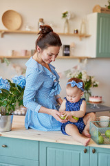 Mother's day greeting card. Family mother and baby daughter in morning have breakfast in kitchen. Spring card for Women's Day March 8. Happy family at home in kitchen. Family festive breakfast. 