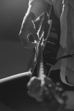 Musician plays guitar hands on strings close up. Theme music.