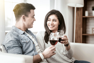 Love you. Positive delighted young family having rest together, drinking red wine