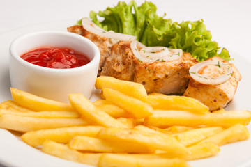 beautiful photo close-up menu of fresh tasty French fries and meat and salad on a plate on a white background