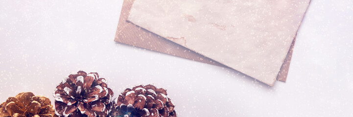 A minimalist panoramic bright Christmas card with cones, snowflakes and an old vintage paper mockup