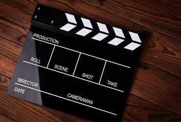 Film slate or movie clapper board on wooden background
