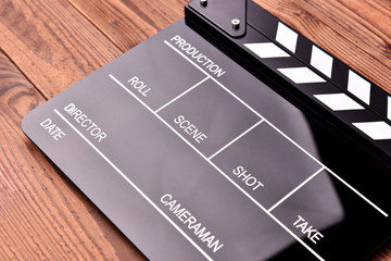 Fototapeta na wymiar Film slate or movie clapper board on wooden background