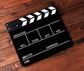 Film slate or movie clapper board on wooden background
