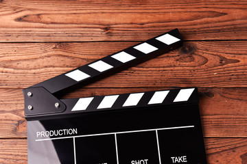 Obraz premium Film slate or movie clapper board on wooden background