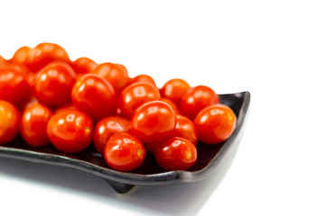 Fresh Tomato in a ceramic cup isolated white background 